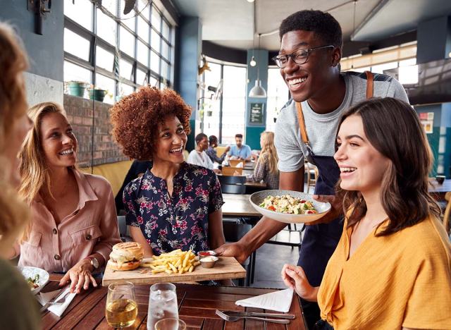 Waiter acting friendly and normal to customers at a restaurant.