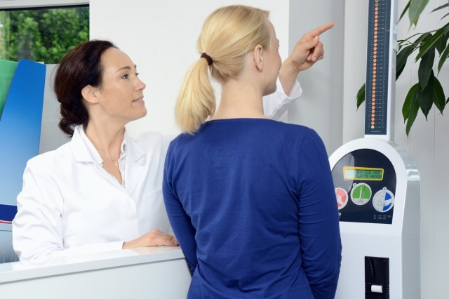 Woman as a patient in pharmacy or doctor's office measures weight and body fat on scales