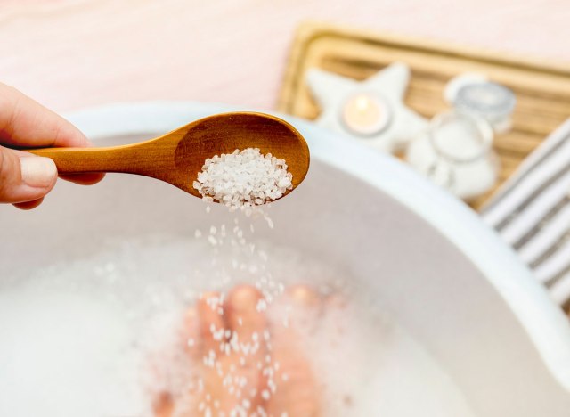 Woman pouring epsom salt into bath