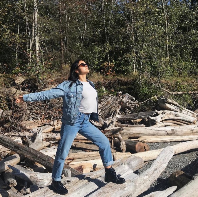 camila mendes in denim jacket and jeans stretching outdoors