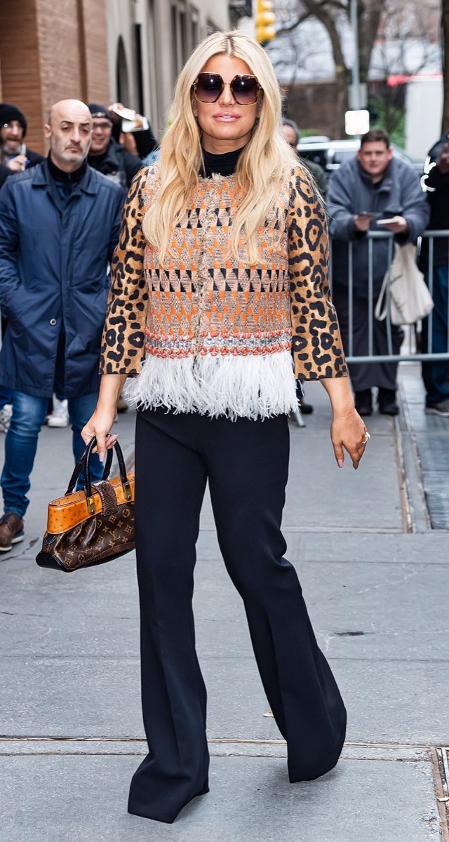 jessica simpson in black pants, leopard top, and fringe vest with louis vuitton bag on street