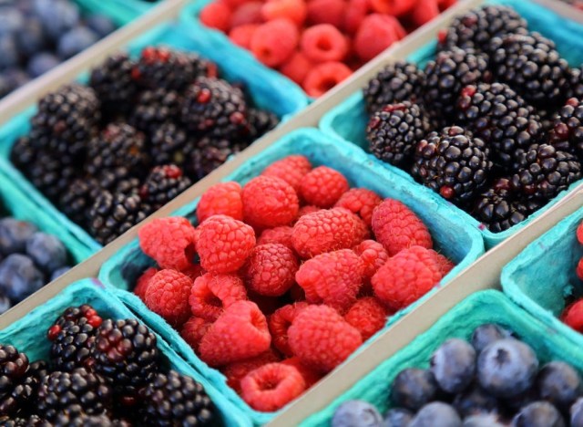 Raspberries, blueberries, and blackberries in crates