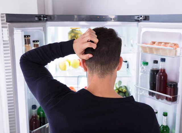 man looking in fridge