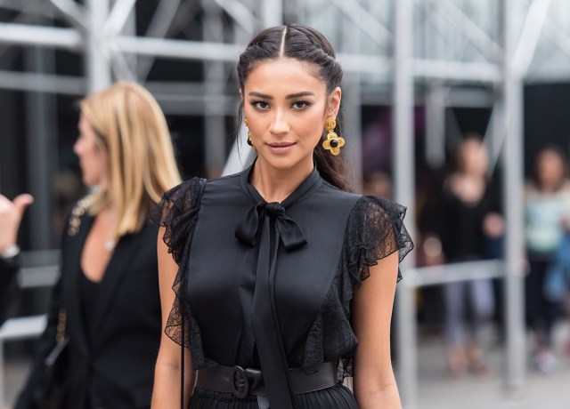 shay mitchell in black dress on city street