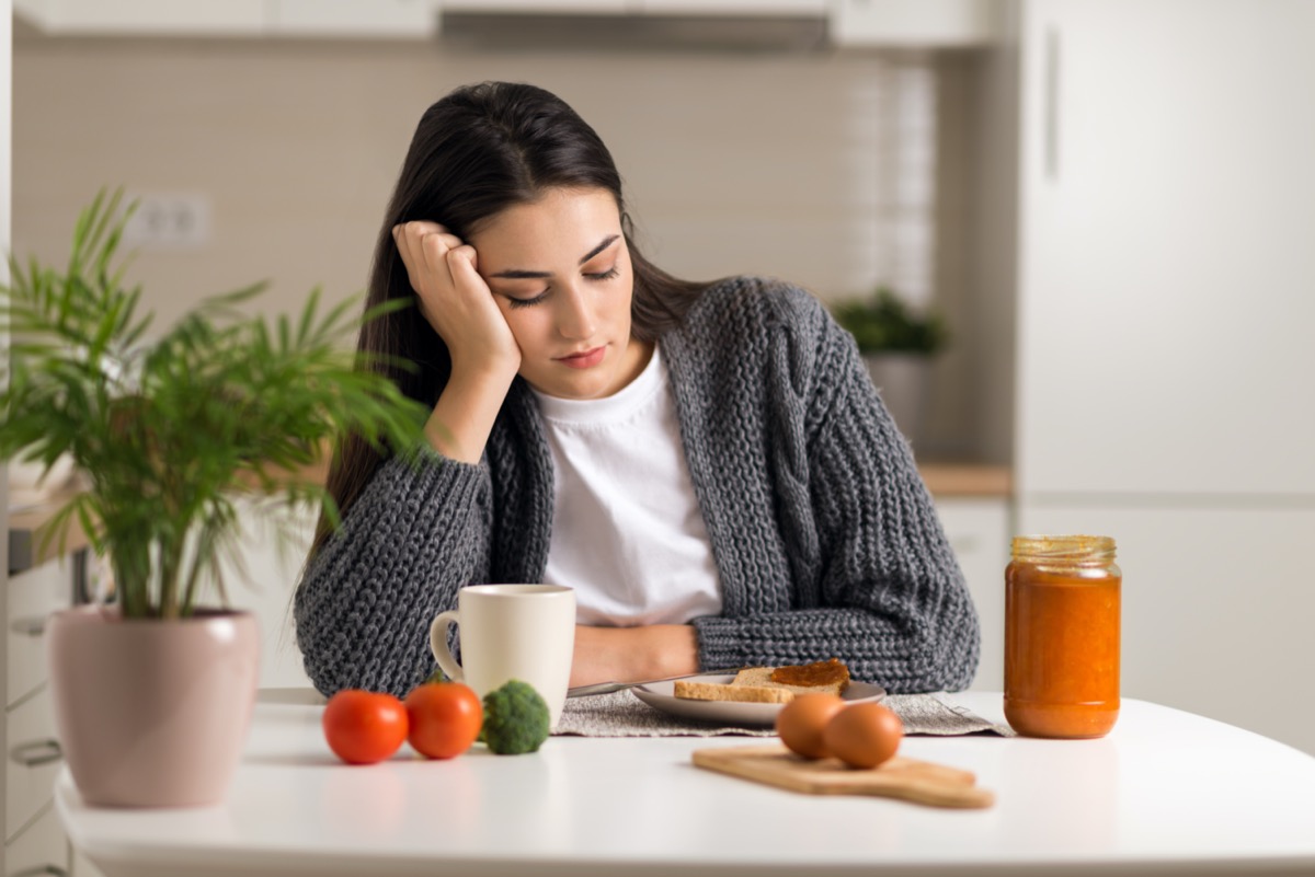 Displeased young woman doesn't want to eat her breakfast