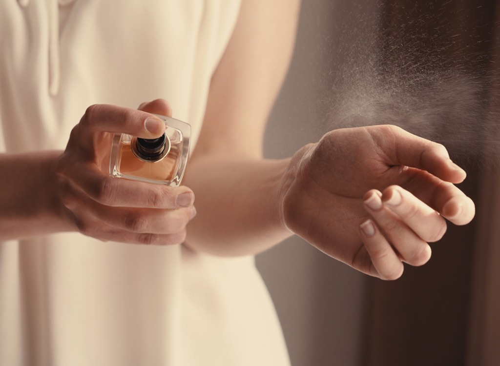 Woman spraying perfume