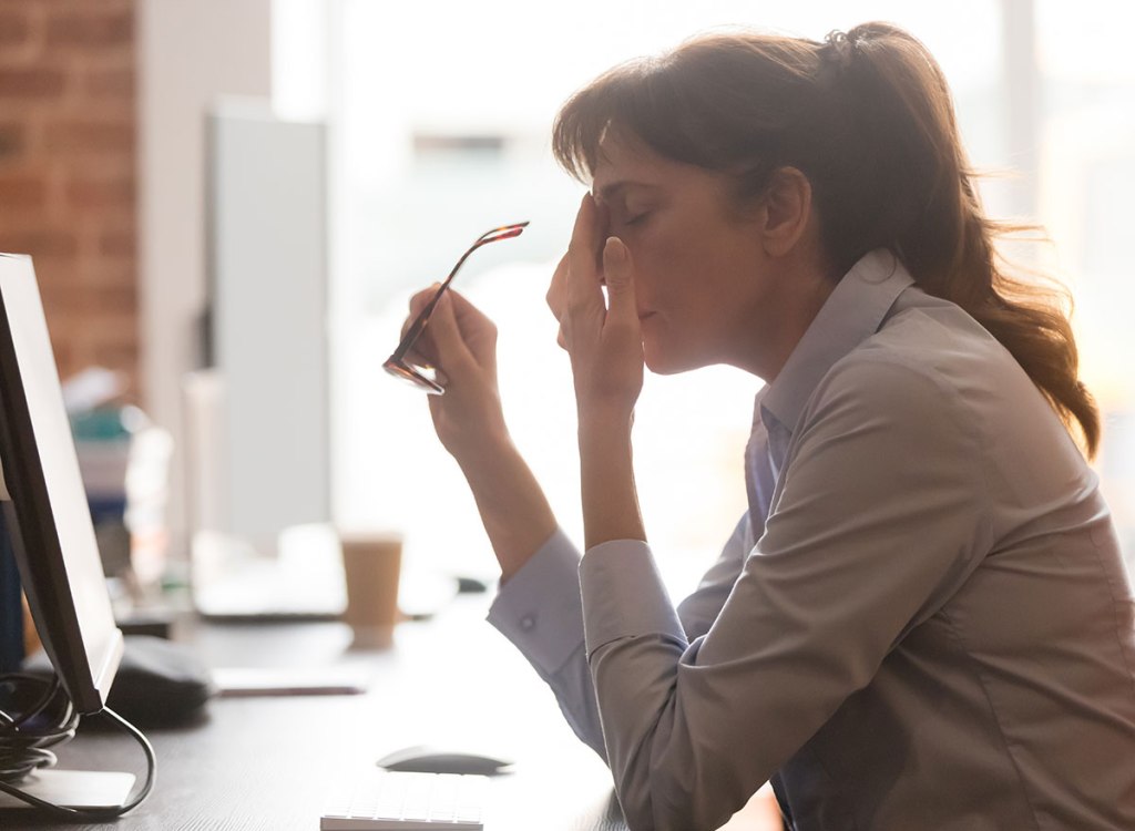 tired female worker sitting at a desk