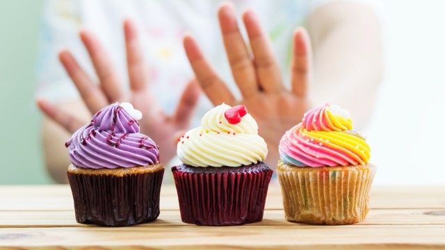 woman refusing cupcakes