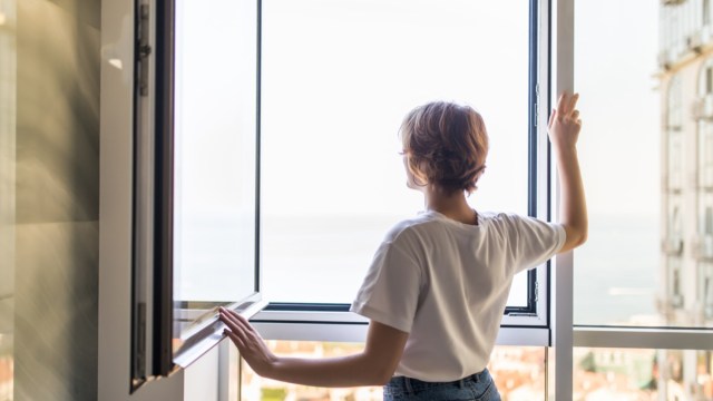 Woman open window in the morning at home