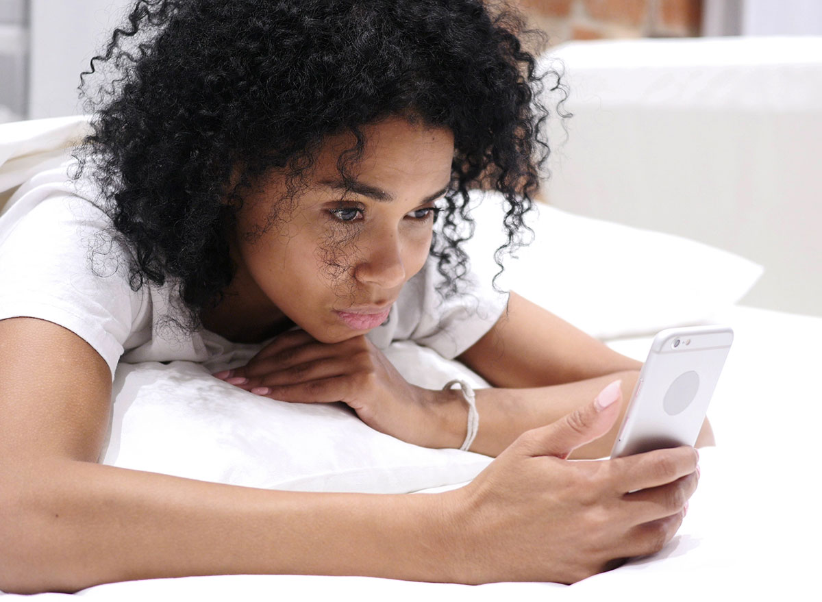 woman on phone in bed