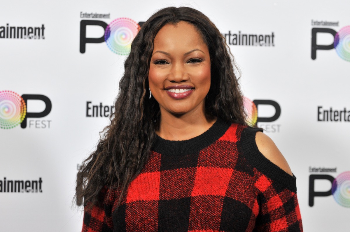 garcelle beauvais in red and black buffalo plaid sweater with exposed shoulders