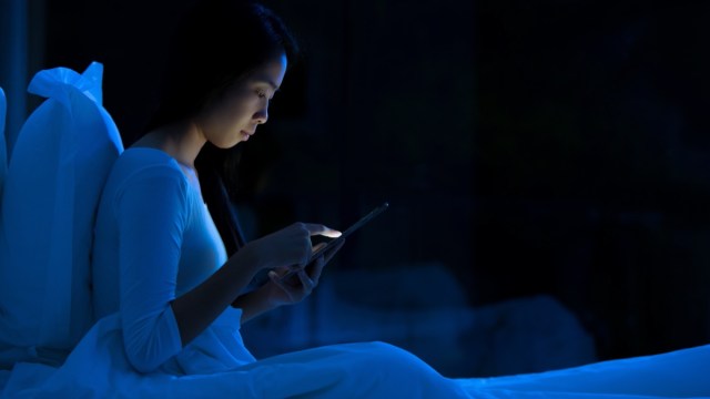 young woman using tablet in bed