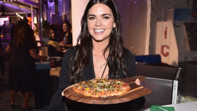 katie lee biegel holding a pan with pizza on it