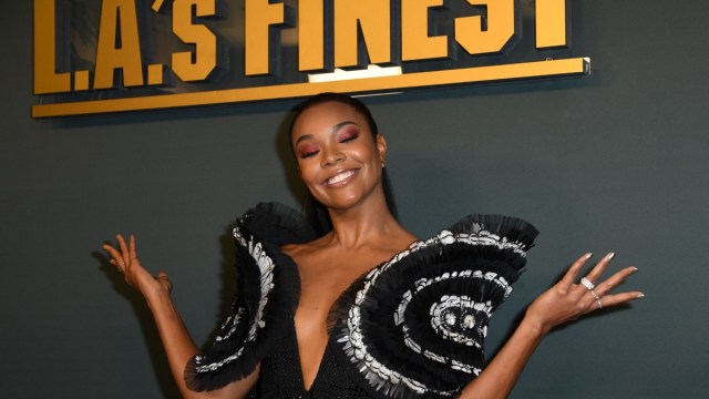 gabrielle union in oversized plunging top in front of la's finest sign