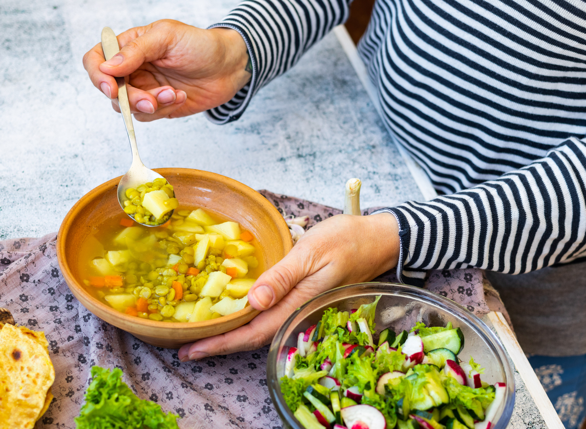 eating soup with spoon and salad