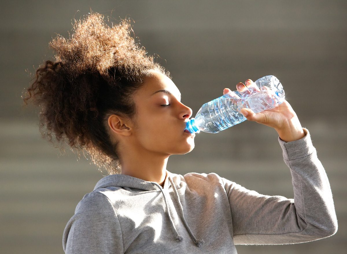 Black woman drinking bottled water