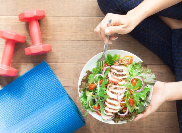 woman with chicken salad, weights, and yoga matt