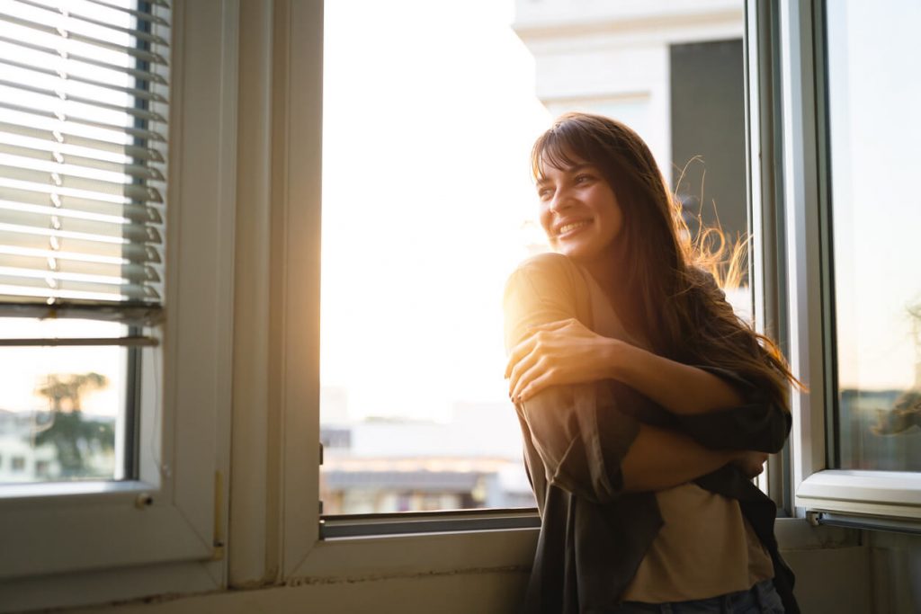 girl smiling by the window how to stop living in the past