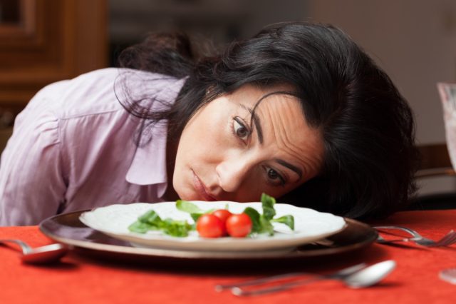 Woman looking to a little salad is tired about diet