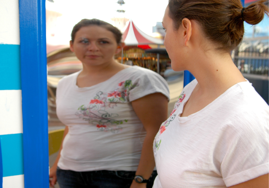 woman looking sadly at her reflection questions to ask about self-esteem